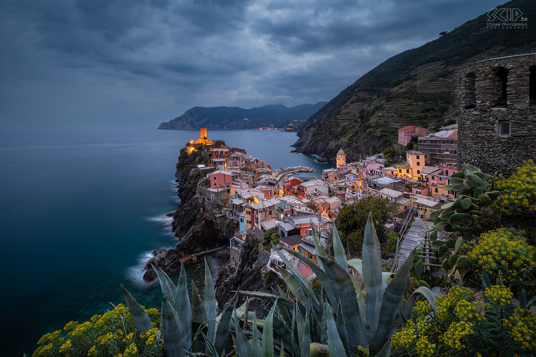 Vernazza - Blauwe uur Vernazza is een van de vijf dorpen van Cinque Terre. Het heeft prachtig gekleurde huizen en een bijzonder mooie haven en baai. Deze foto werd gemaakt vanop een bekende fotolocatie op een helling aan de zuidkant tijdens het blauwe uur op een bewolkte avond. Stefan Cruysberghs